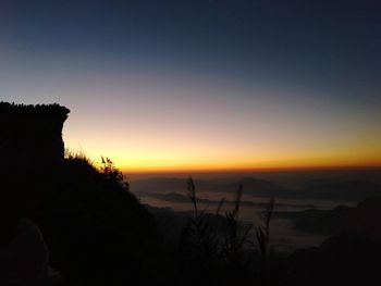 Scenic view of silhouette mountains against sky at sunset