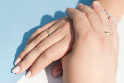 High angle view of hands wearing rings at table