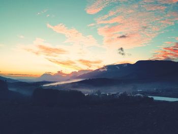 Scenic view of silhouette mountains against sky at sunset