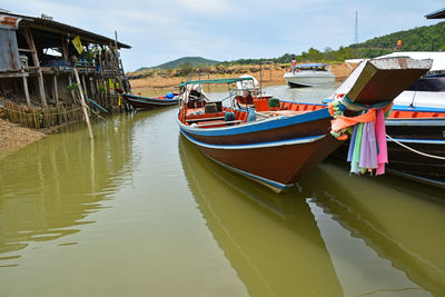 Boats in river with mountain range in background