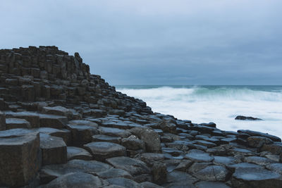 Scenic view of rocky beach against sky