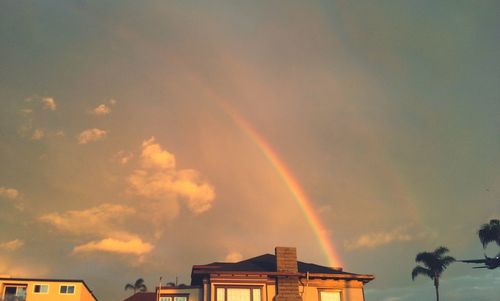 Low angle view of rainbow against cloudy sky