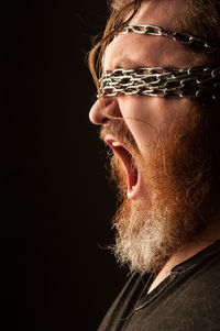 Close-up portrait of man against black background