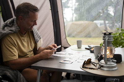 Man playing cards in tent at camping