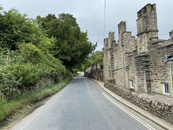 The bolton abbey to burnsall road, as it passes old stone buildings in, bolton abbey, skipton, uk