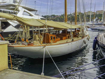 Sailboats moored at harbor