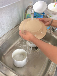 High angle view of hand holding glass of water
