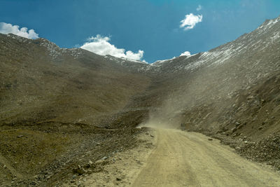 Road amidst mountains against sky
