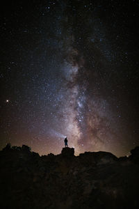 Silhouette man standing against star field at night