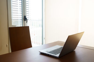 Table and laptop on window at home