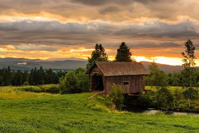 Built structure on field against sky at sunset