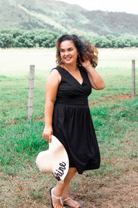 Portrait of a smiling young woman standing on field