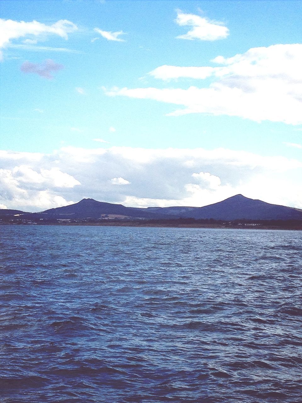 water, waterfront, tranquil scene, sky, scenics, tranquility, mountain, rippled, beauty in nature, sea, nature, cloud - sky, blue, cloud, idyllic, lake, mountain range, day, outdoors, no people