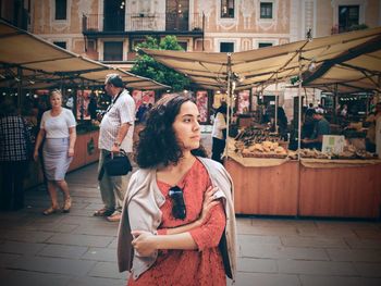 Woman in market against building