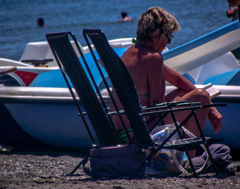 Woman sitting on chair at beach