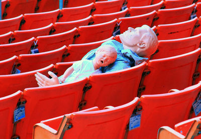 High angle view of mannequins on red chairs at stadium