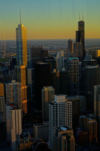 Modern buildings in city against sky during sunset