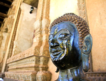 Close-up of buddha statue against wall