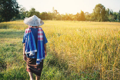 Rear view of farmer standing on field