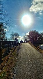 Empty road amidst trees against sky