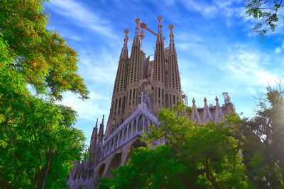 Low angle view of trees and buildings against sky