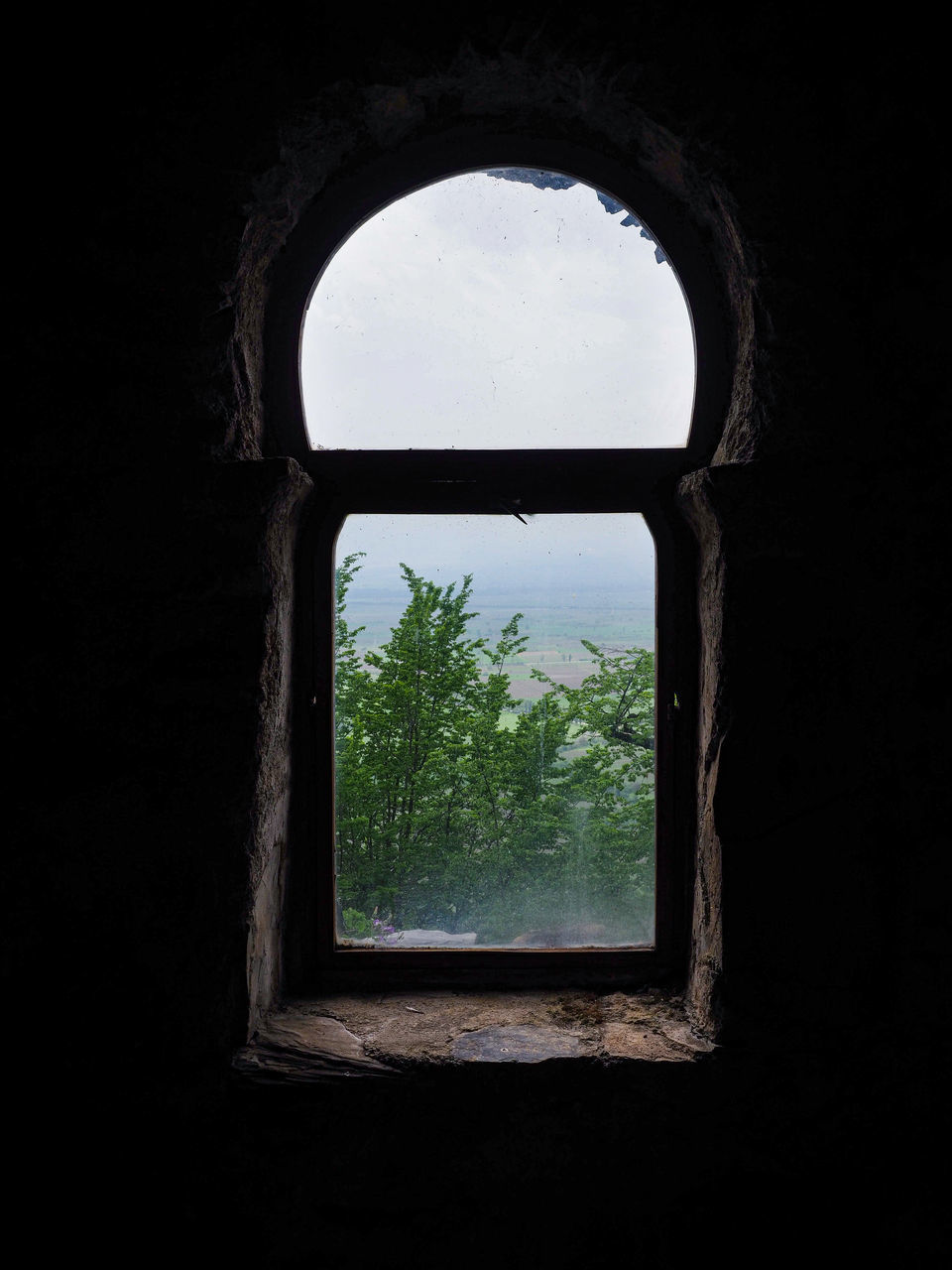 CLOSE-UP OF WINDOW IN ABANDONED ROOM