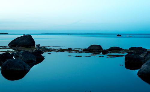 Close-up of rocks in sea against clear sky