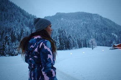 Rear view of woman standing on snow covered landscape