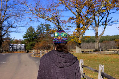 Rear view of woman on tree against sky