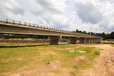 Bridge over field against sky