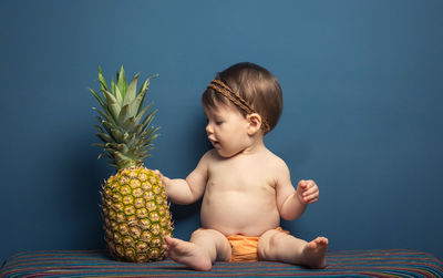 Cute baby boy sitting on blue table