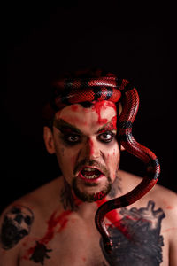 Male portrait with a snake on a black background