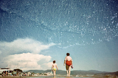 Rear view of men standing on beach