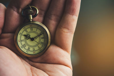 Close-up of hand holding pocket watch