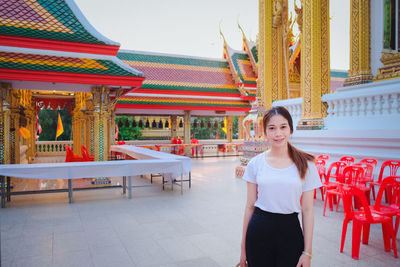 Portrait of young woman standing at temple