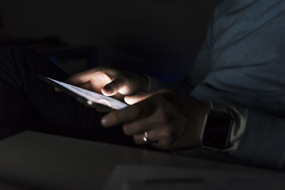 Businessman working on tablet at night, close-up