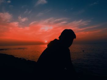 Silhouette man at beach during sunset