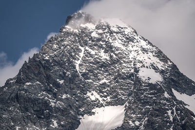 Low angle view of snowcapped mountain against sky