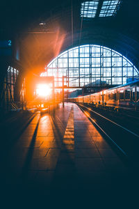 Train at railroad station platform during sunset