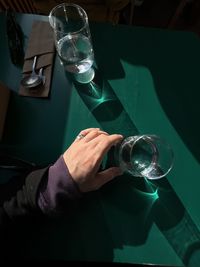 Midsection of man holding water on the green table background