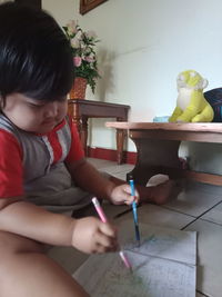 Boy sitting on table at home