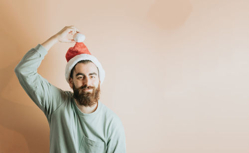 Smiling man with santa hat against wall