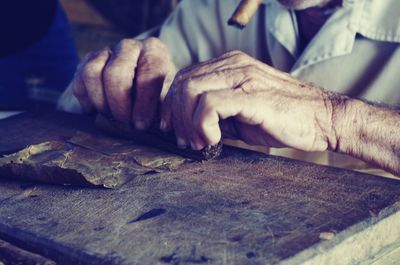 Close-up of man making cigar