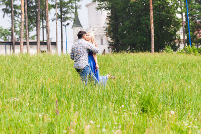 Rear view of couple sitting on field