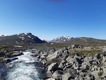 Scenic view of snowcapped mountains against clear blue sky