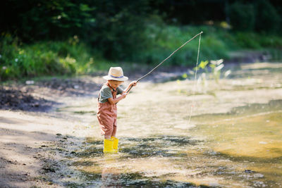 Full length of boy fishing in river