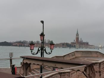 Boats moored in sea against buildings in city