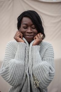 Portrait of beautiful woman standing against wooden wall