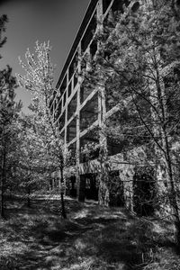 Low angle view of old building by trees against sky