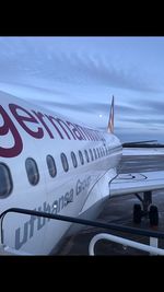 Close-up of airplane on airport runway against sky